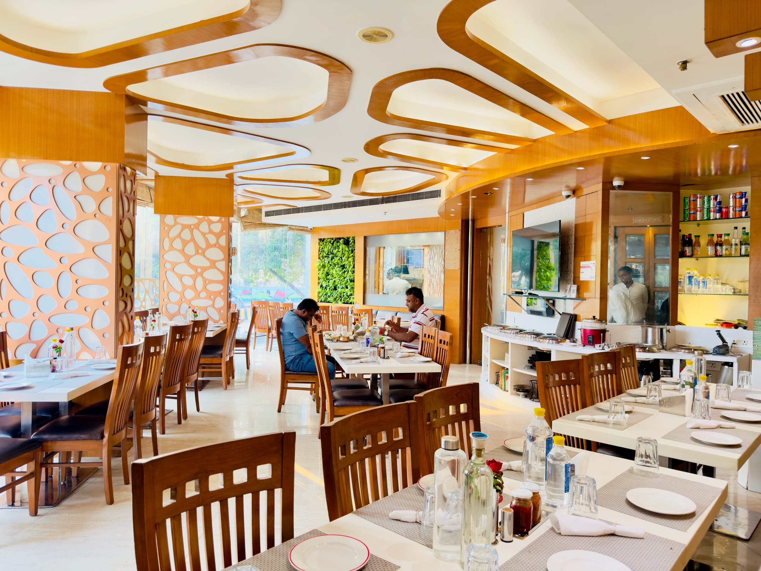 The full dining room at Flavours - daylight from the street windows, staff at the counter