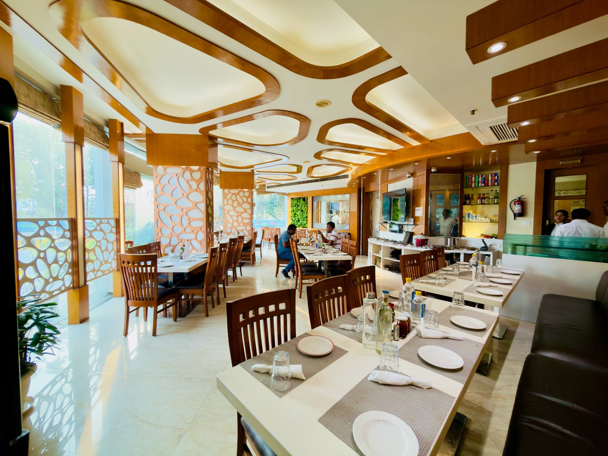 Laid tables at Flavours restaurant - wooden chairs, white runners, the carved ceiling above