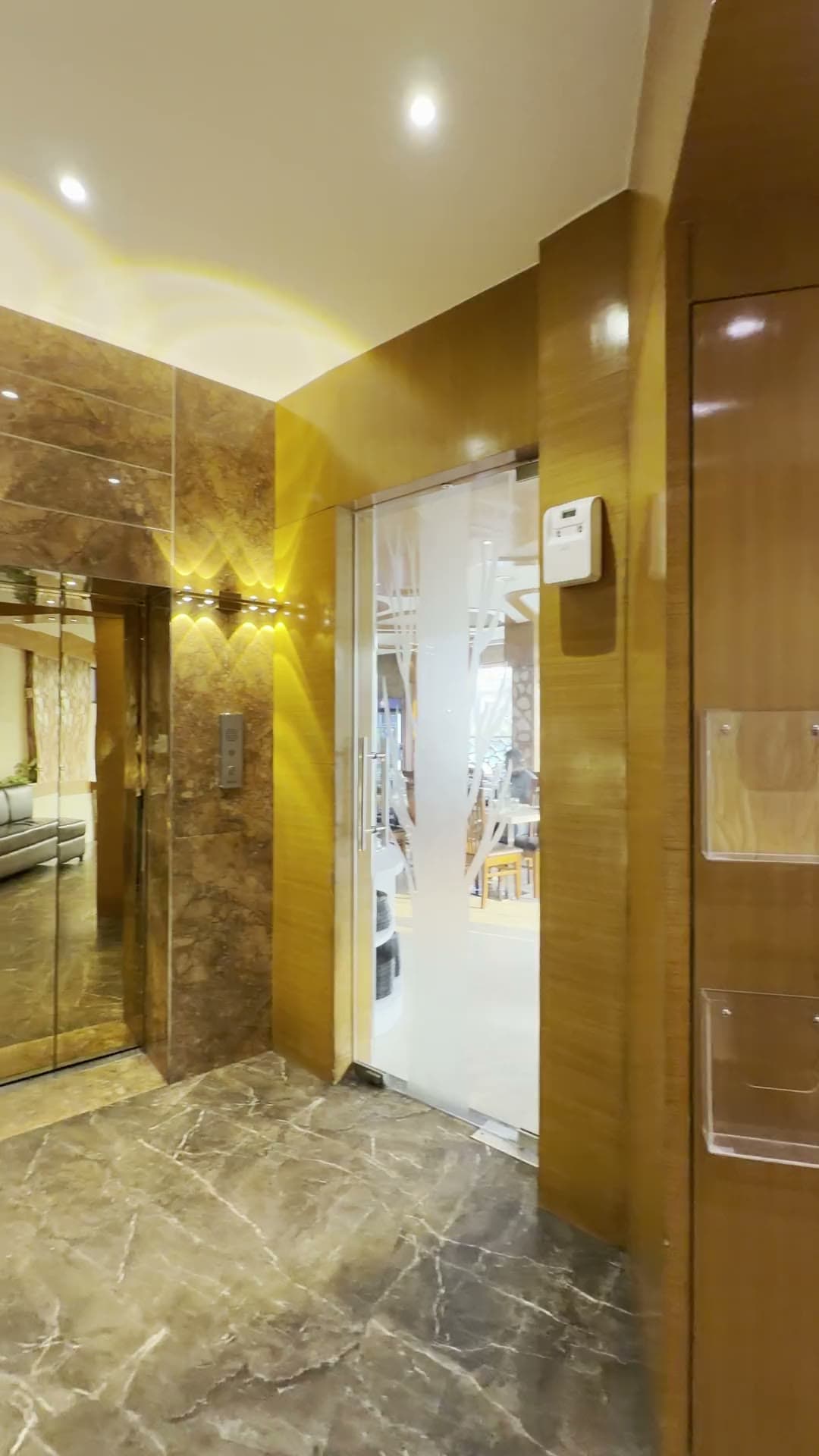 The lobby of Hotel Vagmi, Varanasi - frosted glass doors and a golden jaali screen