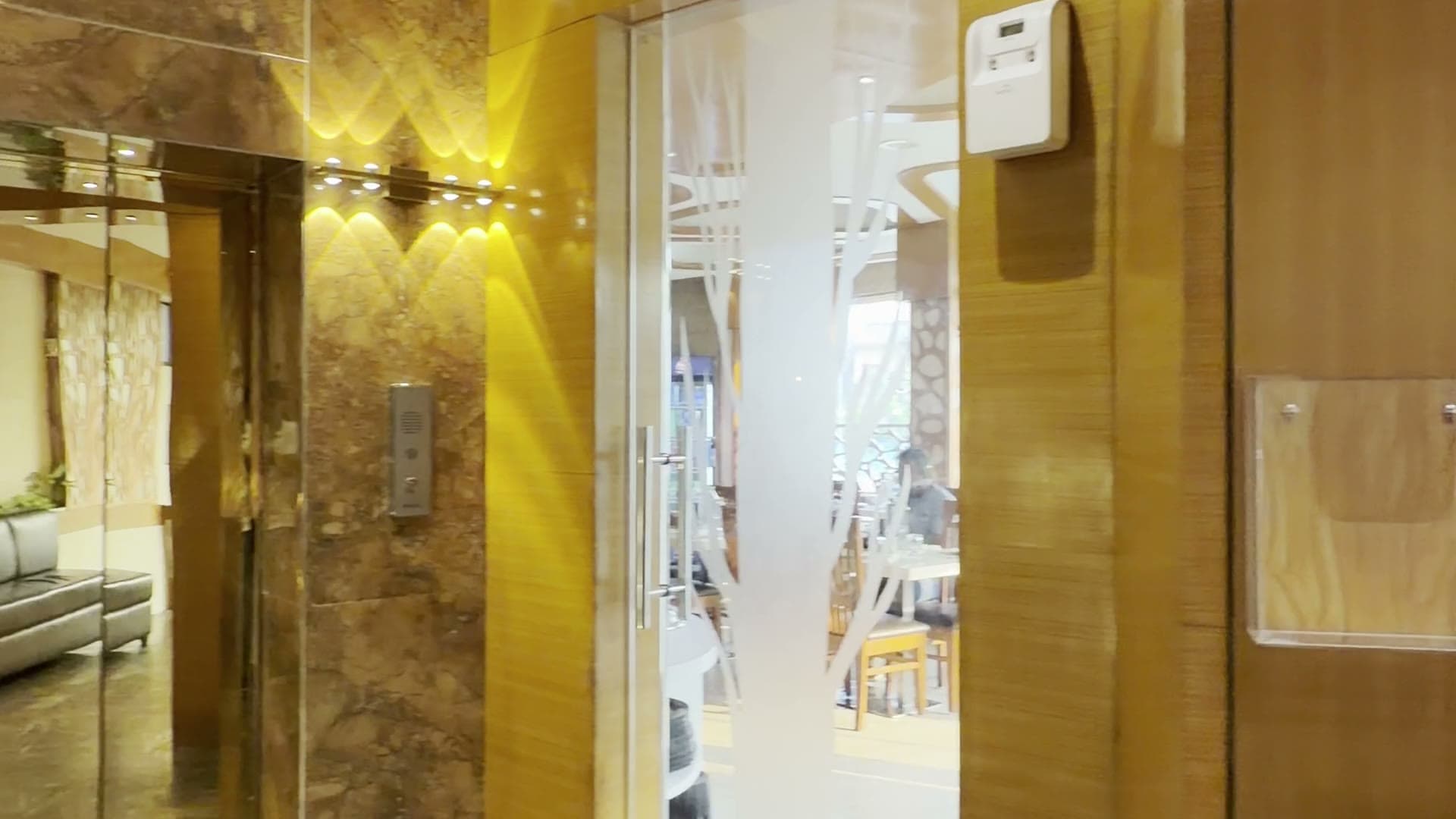 The lobby of Hotel Vagmi, Varanasi - frosted glass doors and a golden jaali screen